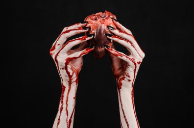 Kanlı korku ve Halloween Tema: korkunç kanlı eller kanlı insan kalbi tutan bir siyah arka plan üzerine siyah çivi ile izole Studio arka plan