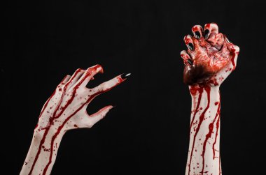 Kanlı korku ve Halloween Tema: korkunç kanlı eller kanlı insan kalbi tutan bir siyah arka plan üzerine siyah çivi ile izole Studio arka plan