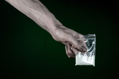 Uyuşturucu ve uyuşturucu bağımlılığı konu karşı mücadele: kirli el çanta bağımlısı kokain stüdyoda koyu yeşil arka plan üzerinde tutarak