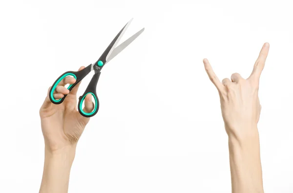 Office and home topic: human hand holding a black scissors with blue accents on a white isolated background in studio — Stock Photo, Image