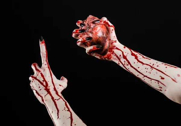 Kanlı korku ve Halloween Tema: korkunç kanlı eller kanlı insan kalbi tutan bir siyah arka plan üzerine siyah çivi ile izole Studio arka plan — Stok fotoğraf