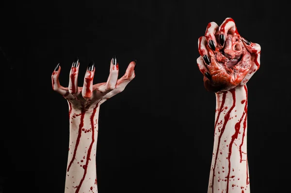 Bloedend, horror en Halloween thema: verschrikkelijk bloedige handen met zwarte nagels houden een bloedige menselijk hart op een zwarte achtergrond geïsoleerd achtergrond in studio — Stockfoto