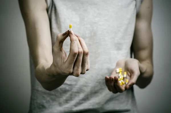 E thème de la lutte contre les drogues et la toxicomanie : un toxicomane tenant un médicament narcotique sur un fond sombre — Photo