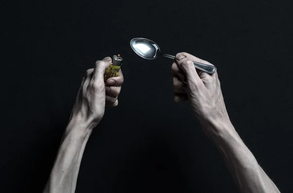Boj proti drogám a drogové závislosti téma: ruka narkoman leží na tmavé stůl a kolem něj jsou léky, top studio — Stock fotografie