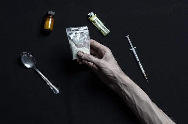 The fight against drugs and drug addiction topic: hand addict lies on a dark table and around it are drugs, a top studio — Stock Photo, Image