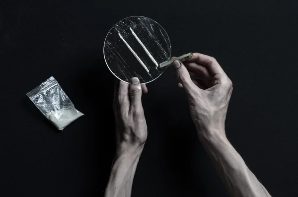 La lutte contre la drogue et la toxicomanie thème : dépendance à la main repose sur une table noire et autour de lui sont les drogues, un studio haut de gamme — Photo