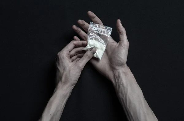 A luta contra as drogas e o tema da toxicodependência: o toxicodependente encontra-se numa mesa escura e à sua volta estão as drogas, um estúdio de topo — Fotografia de Stock