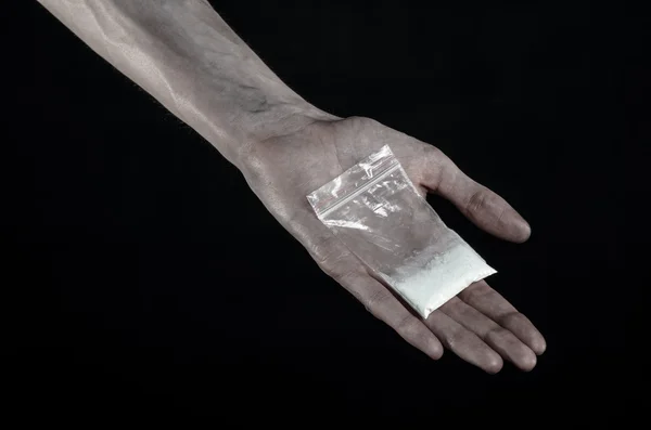 The fight against drugs and drug addiction topic: dirty hand holding a bag addict cocaine on a black background in the studio — Stock Photo, Image