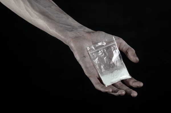 The fight against drugs and drug addiction topic: dirty hand holding a bag addict cocaine on a black background in the studio — Stock Photo, Image