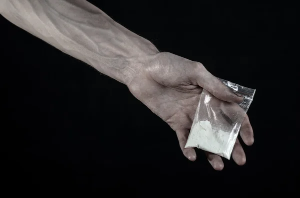 Der Kampf gegen Drogen und Drogenabhängigkeit Thema: schmutzige Hand, die eine Tüte Kokain auf schwarzem Hintergrund im Studio hält — Stockfoto
