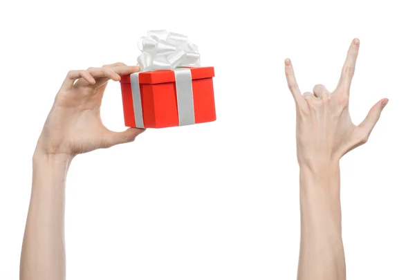 Na temat uroczystości i prezenty: ręka trzyma prezent owinięty w czerwonym polu z biała wstążka i łuk, Najpiękniejszy prezent na białym tle na białym tle w studio — Zdjęcie stockowe