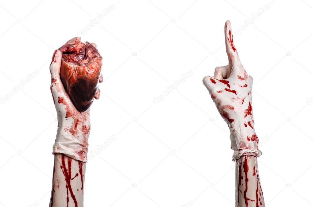 Operation and medicine theme: Bloody hand surgeon holding a human heart in a bloody white gloves isolated on a white background in studio
