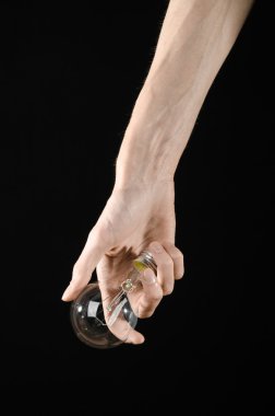 Enerji tüketimi ve enerji tasarrufu Konu: Studio siyah arka plan üzerine bir ampul tutan eller