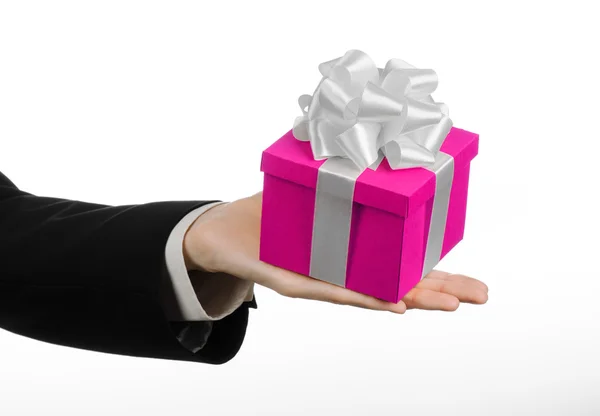 O tema das celebrações e presentes: mão segurando um presente embrulhado em caixa rosa com fita branca e arco, o presente mais bonito isolado no fundo branco no estúdio — Fotografia de Stock