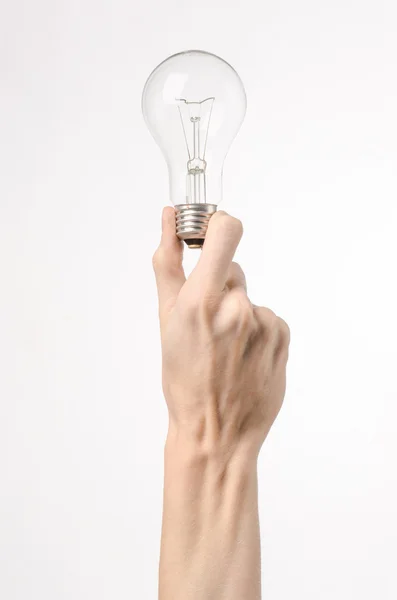 Energieverbruik en energiebesparing onderwerp: menselijke hand met een lampje op een witte achtergrond in studio — Stockfoto