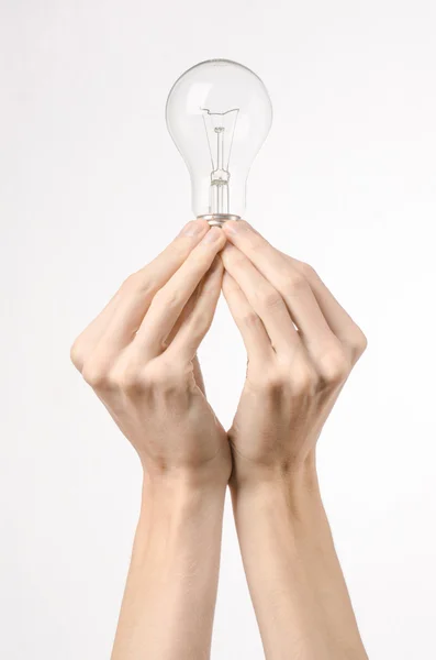 Energieverbruik en energiebesparing onderwerp: menselijke hand met een lampje op een witte achtergrond in studio — Stockfoto