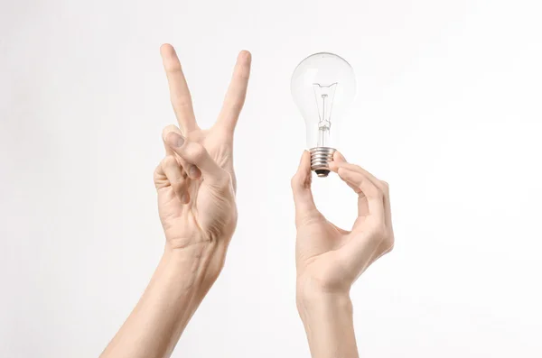 Energieverbruik en energiebesparing onderwerp: menselijke hand met een lampje op een witte achtergrond in studio — Stockfoto