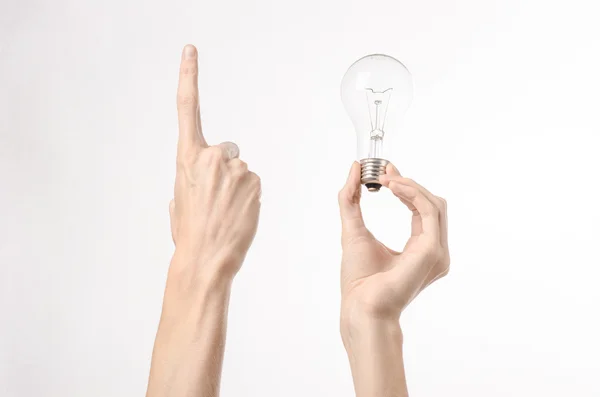 Consumo de energia e tópico de economia de energia: mão humana segurando uma lâmpada em um fundo branco no estúdio — Fotografia de Stock