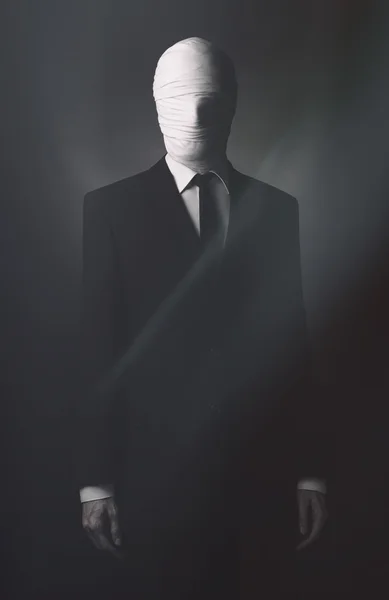 Meme da Internet e tema de Halloween personagem terrível: homem corpulento muito alto com braços longos em um terno com tecido de rosto enfaixado, um assassino desconhecido no terno, The Slender Man, lenda secreta da cidade — Fotografia de Stock