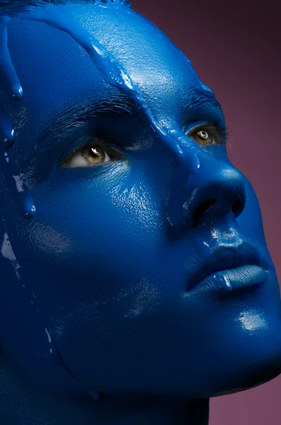 Portrait of a man poured blue paint on a pink background — Stock Photo, Image