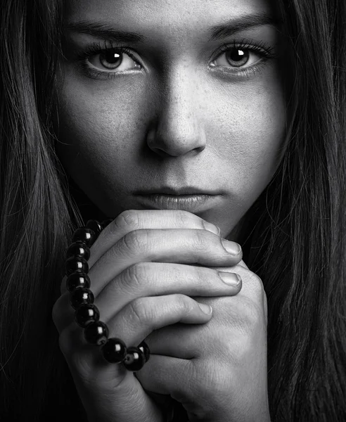Porträt eines schönen jungen Mädchens mit einem Rosenkranz in seinen Händen — Stockfoto