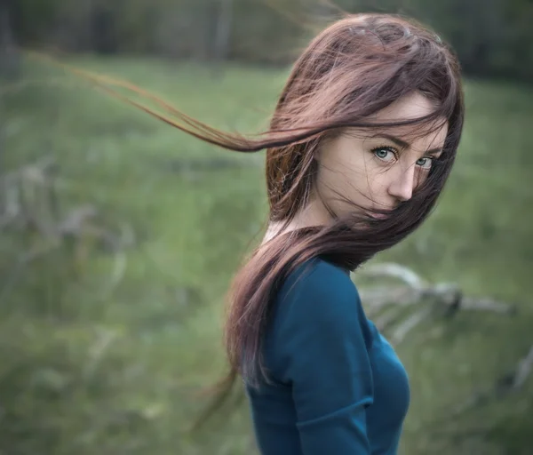 Retrato dramático de um tema de menina: retrato de uma menina bonita com cabelo voador no vento na floresta — Fotografia de Stock