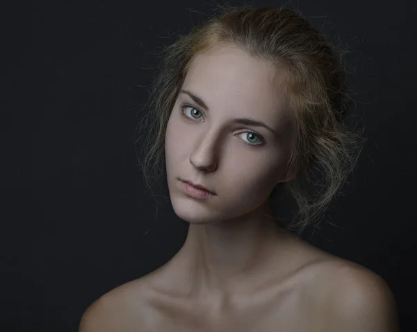 Retrato dramático de um tema de menina: retrato de uma menina bonita em um fundo escuro no estúdio — Fotografia de Stock