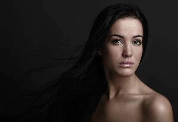 Dramatische portret van een meisje thema: portret van een mooi meisje met vliegende haren in de wind tegen een achtergrond in de studio — Stockfoto