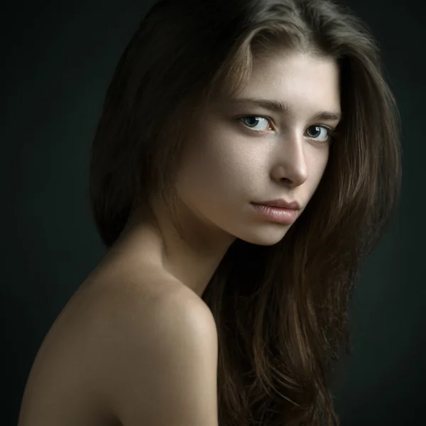 Dramatic portrait of a girl theme: portrait of a beautiful girl on a dark background in studio — Stock Photo, Image