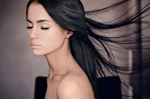 Dramatic portrait of a girl theme: portrait of a beautiful lonely girl with flying hair in the wind isolated on dark background in studio — Stock Photo, Image