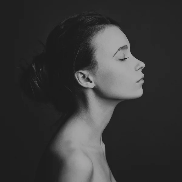 Dramatic portrait of a girl theme: portrait of a beautiful girl on a dark background in studio — Stock Photo, Image