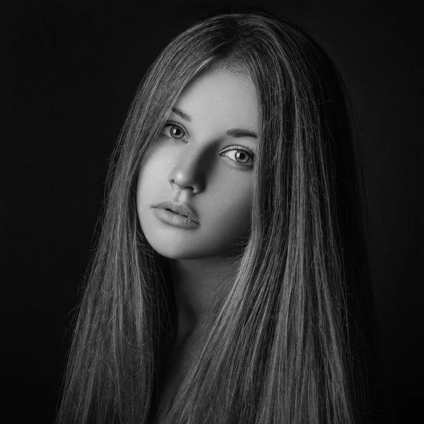 Dramatic portrait of a girl theme: portrait of a beautiful girl on a dark background in studio — Stock Photo, Image