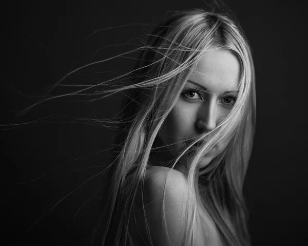 Dramatic portrait of a girl theme: portrait of a beautiful lonely girl with flying hair in the wind isolated on dark background in studio — Stock Photo, Image