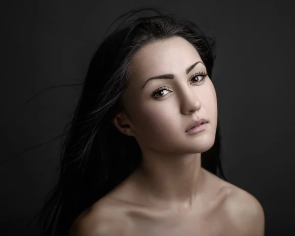 Retrato dramático de un tema de niña: retrato de una hermosa chica solitaria con el pelo volando en el viento aislado sobre fondo oscuro en el estudio —  Fotos de Stock