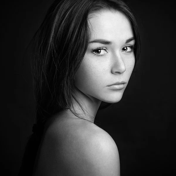 Dramatiska porträtt av en flicka tema: porträtt av en vacker flicka på en mörk bakgrund i studio — Stockfoto