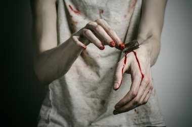 Depresyon ve kanlı Halloween Tema: stüdyo gri bir arka plan üzerine intihar için kanlı bir ustura tutan bir adam