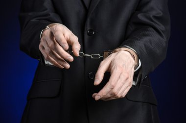 Yolsuzluk ve rüşvet Tema: işadamı kelepçe elindeki Studio izole koyu mavi zemin üzerine siyah elbiseli
