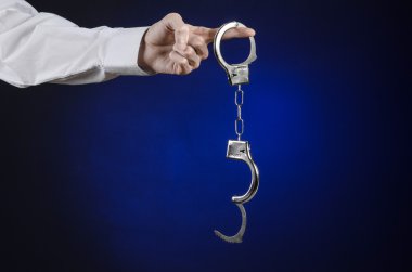 Dürüst olmayan ve bir hapishane doktor Konu: ile kelepçe Studio, Doktor, organları yasadışı satışı kelepçe koymak koyu mavi zemin üzerine beyaz gömlekli adamın elini