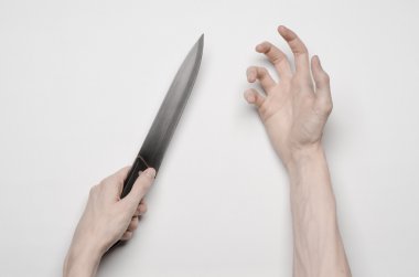 Cinayet ve Halloween Tema: bir bıçak için ulaşan bir elini, bir insan eli elinde bir bıçak izole Studio yukarıdan gri bir arka plan üzerinde