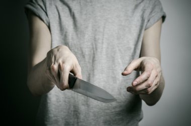 Cinayet ve Halloween Tema: gri bir arka plan üzerinde elinde bir bıçakla bir adam