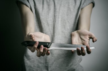 Cinayet ve Halloween Tema: gri bir arka plan üzerinde elinde bir bıçakla bir adam