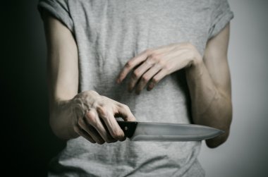 Cinayet ve Halloween Tema: gri bir arka plan üzerinde elinde bir bıçakla bir adam