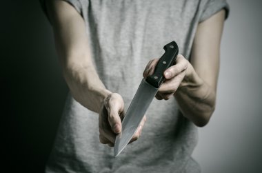 Cinayet ve Halloween Tema: gri bir arka plan üzerinde elinde bir bıçakla bir adam
