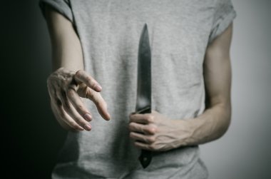 Cinayet ve Halloween Tema: gri bir arka plan üzerinde elinde bir bıçakla bir adam