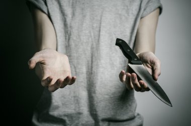 Cinayet ve Halloween Tema: gri bir arka plan üzerinde elinde bir bıçakla bir adam