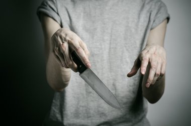 Cinayet ve Halloween Tema: gri bir arka plan üzerinde elinde bir bıçakla bir adam