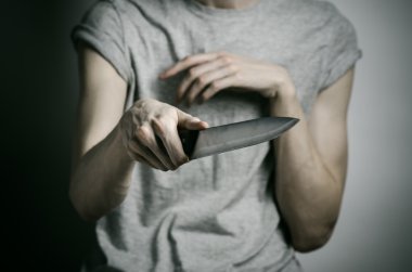 Cinayet ve Halloween Tema: gri bir arka plan üzerinde elinde bir bıçakla bir adam