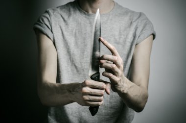 Cinayet ve Halloween Tema: gri bir arka plan üzerinde elinde bir bıçakla bir adam