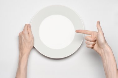 Restoran ve gıda Tema: insan eli göstermek jest beyaz bir arka plan üzerinde boş bir beyaz tabakta izole studio Üstten Görünüm