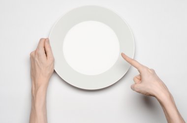 Restoran ve gıda Tema: insan eli göstermek jest beyaz bir arka plan üzerinde boş bir beyaz tabakta izole studio Üstten Görünüm